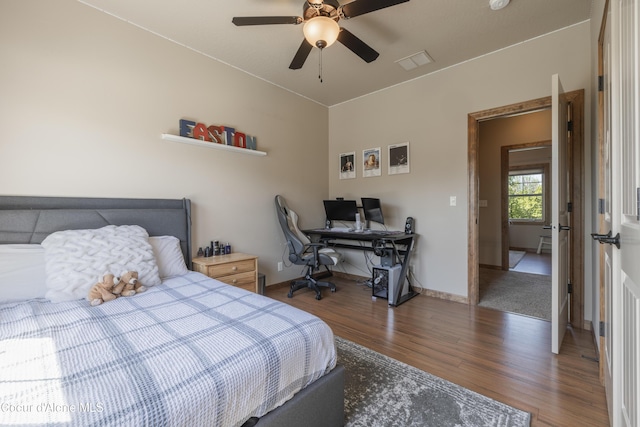 bedroom with wood finished floors, a desk, baseboards, and a ceiling fan