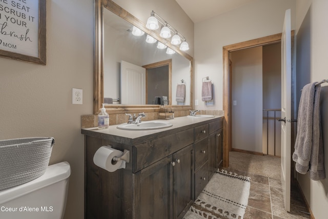 full bathroom featuring double vanity and toilet