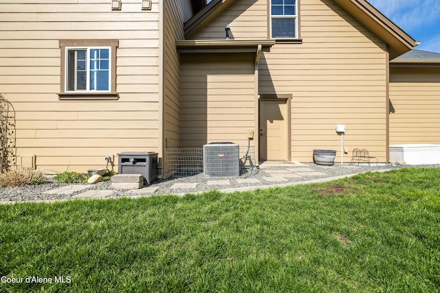 rear view of house with a yard and cooling unit