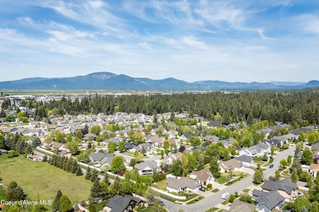 aerial view of property's location with a mountainous background and nearby suburban area