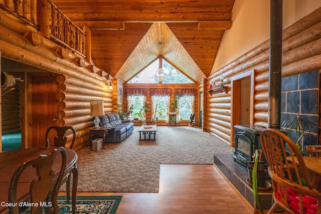 living room with a wood stove, high vaulted ceiling, wood ceiling, log walls, and wood finished floors