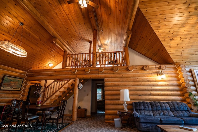 living area featuring ceiling fan, stairs, log walls, wooden ceiling, and high vaulted ceiling