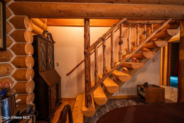 staircase with log walls and baseboards