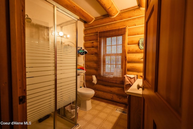 full bathroom featuring rustic walls, a shower stall, toilet, tile patterned floors, and beamed ceiling