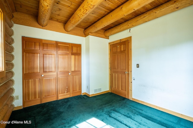 unfurnished bedroom featuring wooden ceiling, dark carpet, baseboards, and beamed ceiling