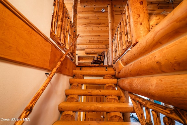 stairway with rustic walls and a towering ceiling
