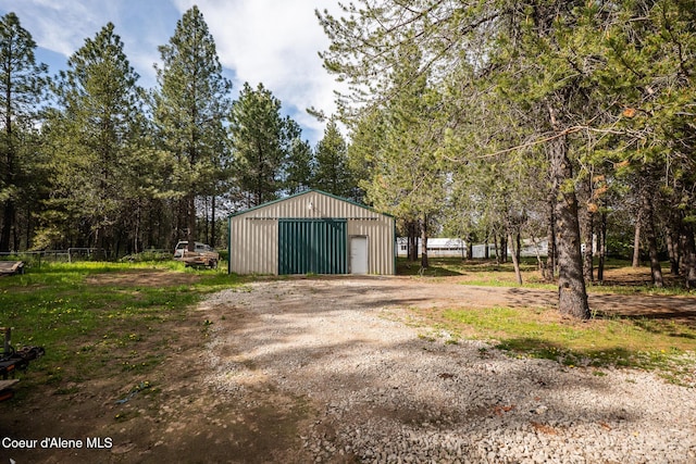 detached garage featuring dirt driveway