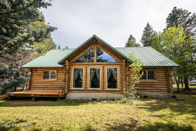 rear view of house featuring log siding, a wooden deck, crawl space, a yard, and metal roof