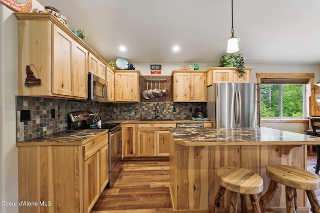 304 Hagman Rd, Nordman, ID 83848 - kitchen with appliances with stainless steel finishes, dark countertops, light brown cabinetry, wood finished floors, and recessed lighting