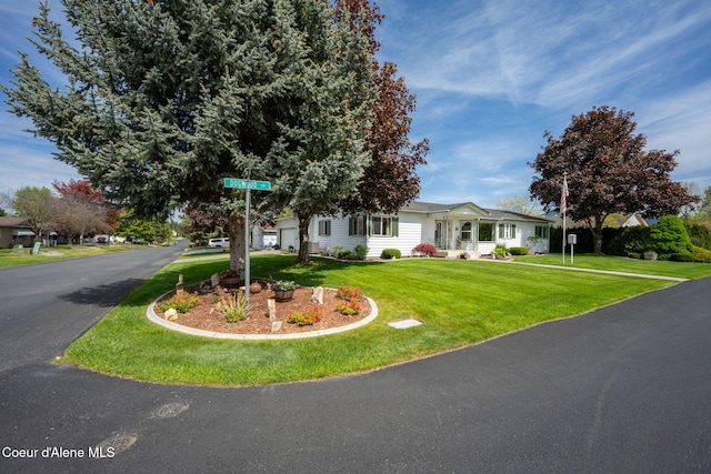 view of front of property featuring a front lawn, a garage, and driveway