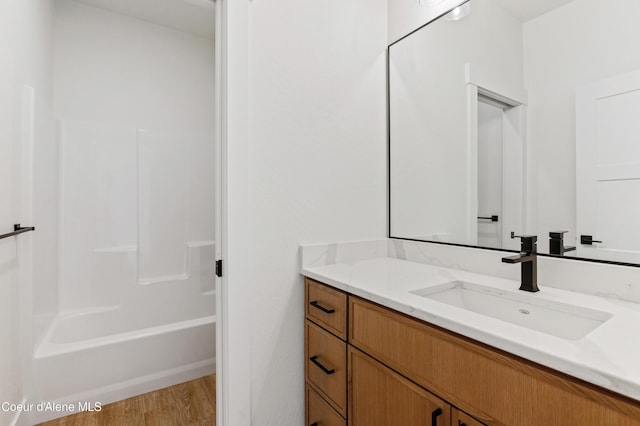 full bathroom featuring wood finished floors, vanity, and shower / bathtub combination