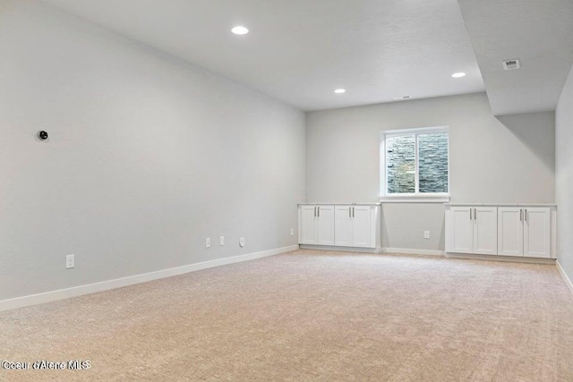empty room with light carpet, recessed lighting, and baseboards
