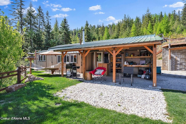 12251 W Blessing Hill Rd, Post Falls, ID 83854 - view of community featuring a lawn, a wooded view, and a patio area