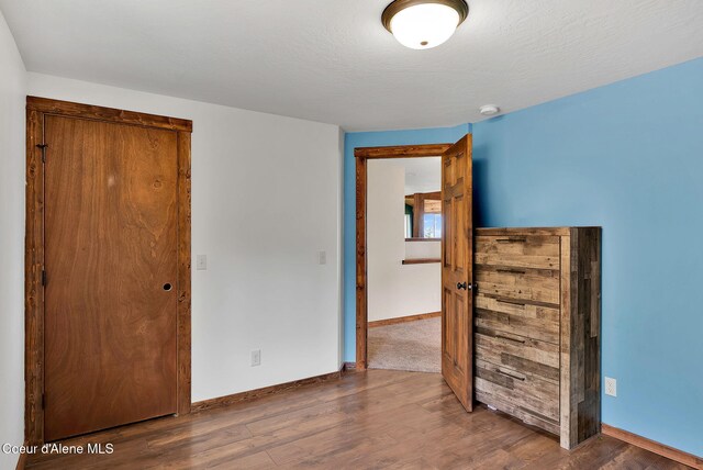 12251 W Blessing Hill Rd, Post Falls, ID 83854 - unfurnished bedroom featuring baseboards and wood finished floors
