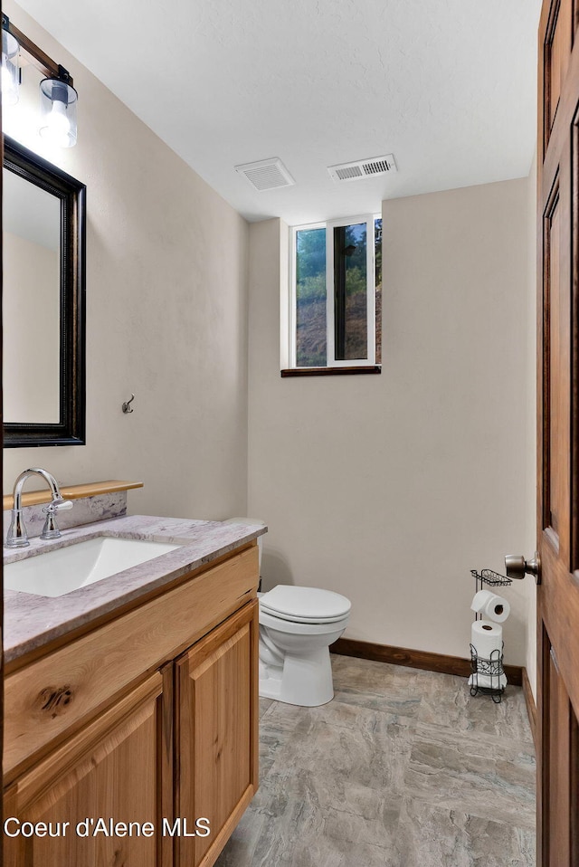 12251 W Blessing Hill Rd, Post Falls, ID 83854 - half bath featuring toilet, vanity, and baseboards