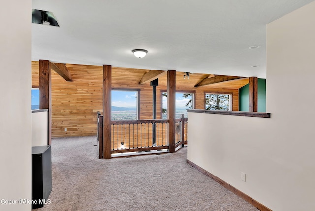 12251 W Blessing Hill Rd, Post Falls, ID 83854 - corridor featuring wood walls, carpet floors, beamed ceiling, baseboards, and an upstairs landing