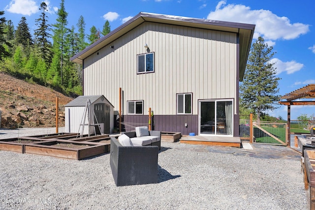 12251 W Blessing Hill Rd, Post Falls, ID 83854 - back of house featuring a storage unit, an outbuilding, a vegetable garden, fence, and a gate