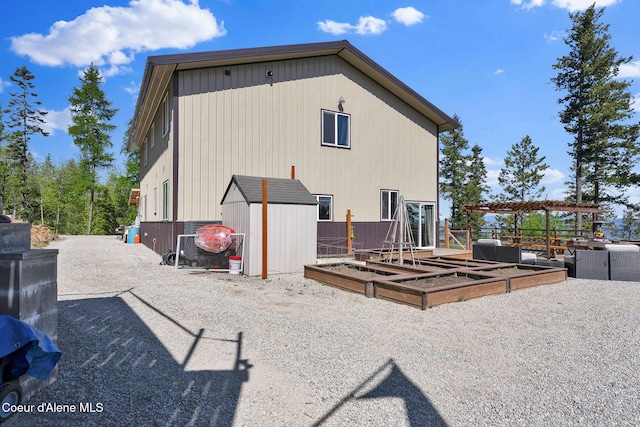 12251 W Blessing Hill Rd, Post Falls, ID 83854 - rear view of house with a garden, an outbuilding, a storage unit, and fence