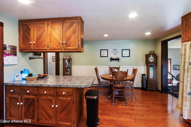 249 Gun Club Rd, Sagle, ID 83860 - kitchen featuring wood finished floors, a peninsula, recessed lighting, and brown cabinetry