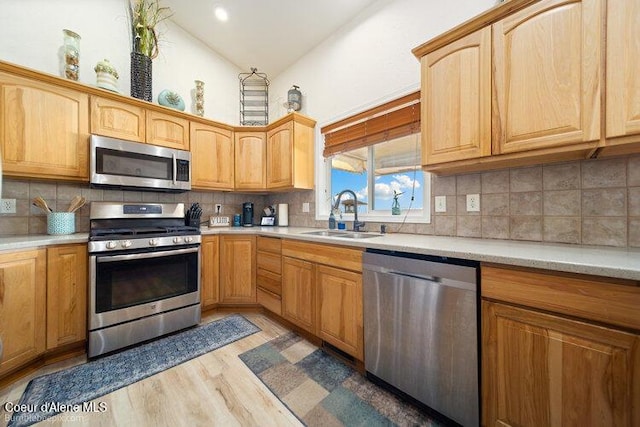 4411 N Campbell Rd, Otis Orchards, WA 99027 - kitchen featuring appliances with stainless steel finishes, a sink, light wood finished floors, light countertops, and high vaulted ceiling