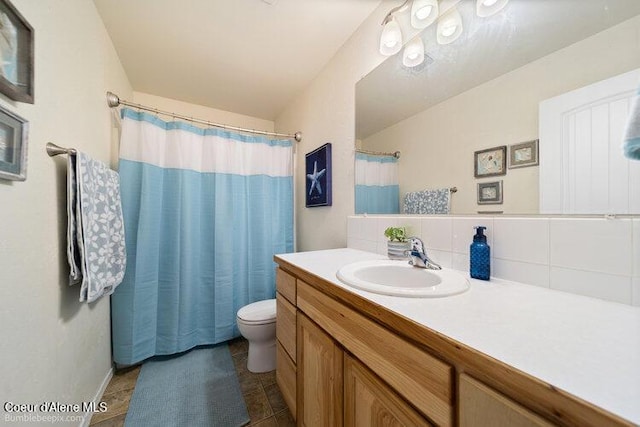 4411 N Campbell Rd, Otis Orchards, WA 99027 - full bath featuring vanity, toilet, decorative backsplash, tile patterned flooring, and a shower with curtain