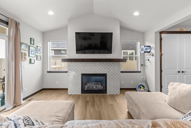 3172 N Cyprus Fox Loop, Post Falls, ID 83854 - living room featuring vaulted ceiling, wood finished floors, a tile fireplace, baseboards, and recessed lighting