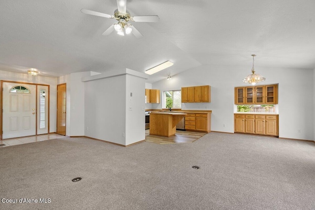 1100 E Autumn Crest Loop, Post Falls, ID 83854 - unfurnished living room with baseboards, light carpet, lofted ceiling, and ceiling fan