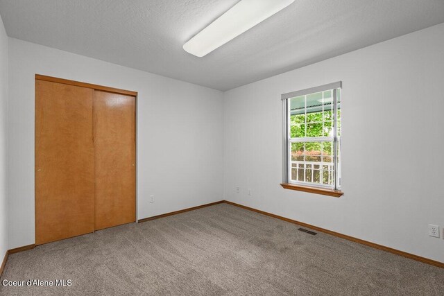 1100 E Autumn Crest Loop, Post Falls, ID 83854 - unfurnished bedroom featuring carpet, a closet, and baseboards