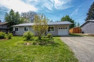 1223 W Superior, Sandpoint, ID 83864 - view of front of property featuring a garage, dirt driveway, and a front lawn