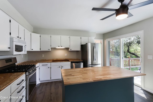1223 W Superior, Sandpoint, ID 83864 - kitchen featuring appliances with stainless steel finishes, wood counters, dark wood-style flooring, white cabinets, and a ceiling fan
