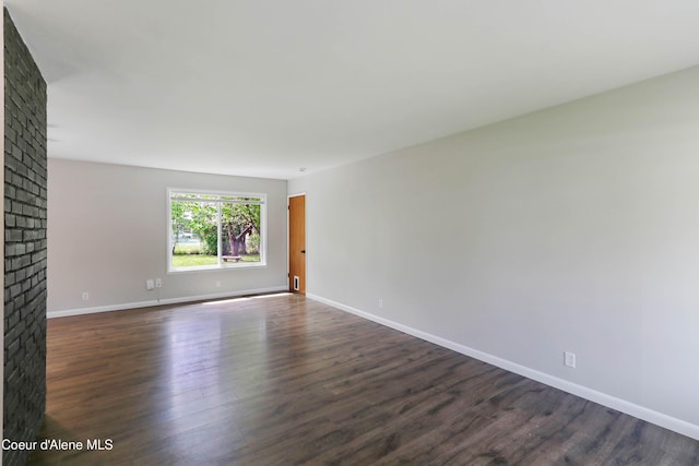 1223 W Superior, Sandpoint, ID 83864 - spare room featuring dark wood finished floors, a brick fireplace, and baseboards