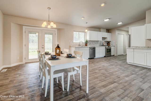 30603 N Riffle Rd, Spirit Lake, ID 83869 - dining room with light wood-style flooring, french doors, baseboards, a chandelier, and recessed lighting