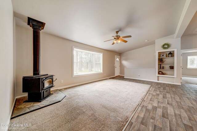 30603 N Riffle Rd, Spirit Lake, ID 83869 - unfurnished living room with wood finished floors, a ceiling fan, lofted ceiling, a wood stove, and baseboards