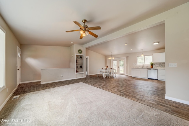 30603 N Riffle Rd, Spirit Lake, ID 83869 - unfurnished living room with vaulted ceiling, baseboards, dark carpet, dark wood finished floors, and a sink