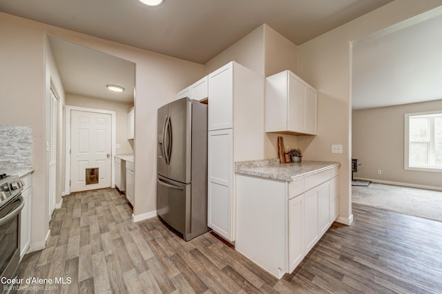 30603 N Riffle Rd, Spirit Lake, ID 83869 - kitchen featuring appliances with stainless steel finishes, white cabinetry, light wood finished floors, and baseboards