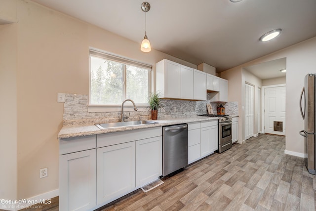 30603 N Riffle Rd, Spirit Lake, ID 83869 - kitchen featuring appliances with stainless steel finishes, a sink, backsplash, and white cabinetry