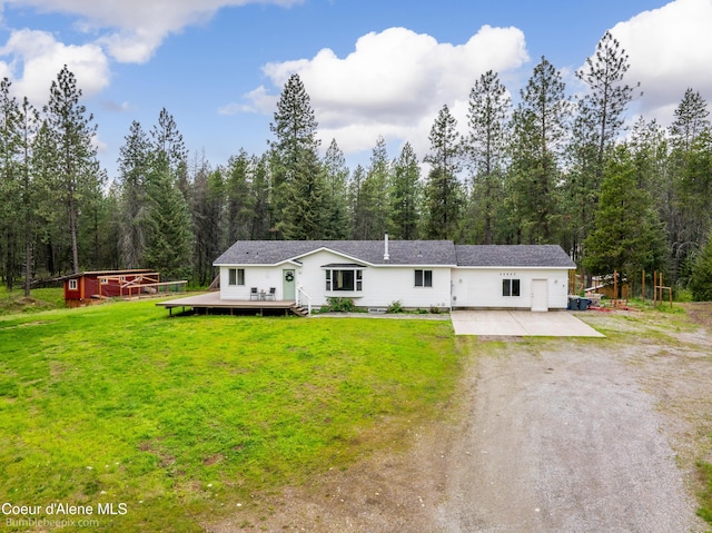 30603 N Riffle Rd, Spirit Lake, ID 83869 - view of front of property featuring dirt driveway, a deck, a front lawn, and a forest view