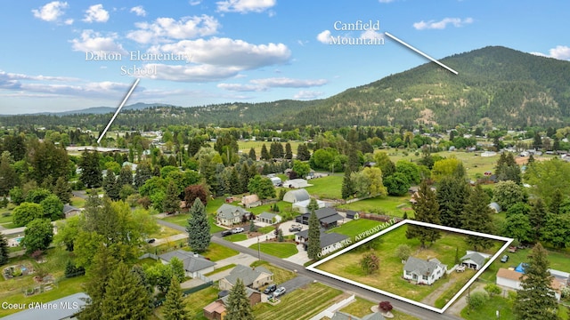 aerial overview of property's location with property parcel outlined, mountains, and a heavily wooded area