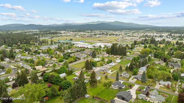 aerial view of property and surrounding area with a mountain backdrop and nearby suburban area