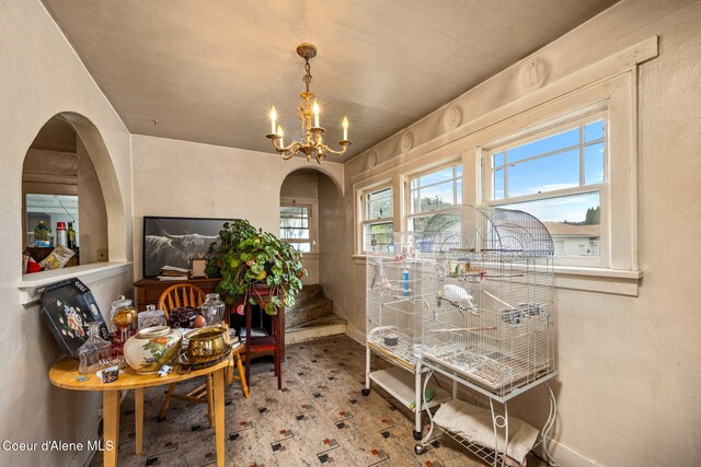 home office with a chandelier, baseboards, and arched walkways