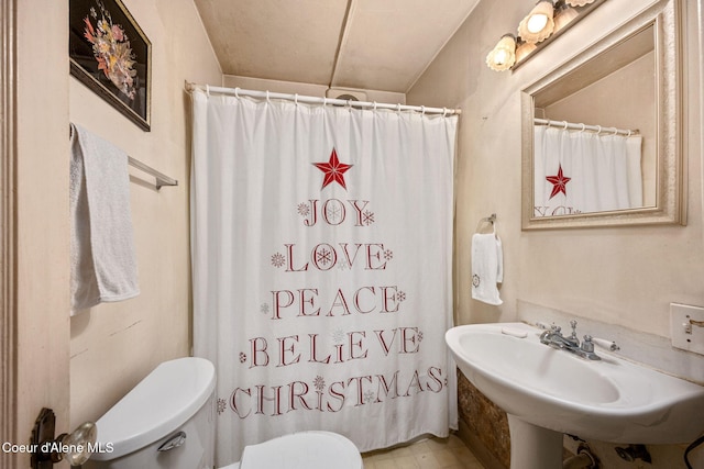 full bath with toilet, a sink, and a shower with shower curtain