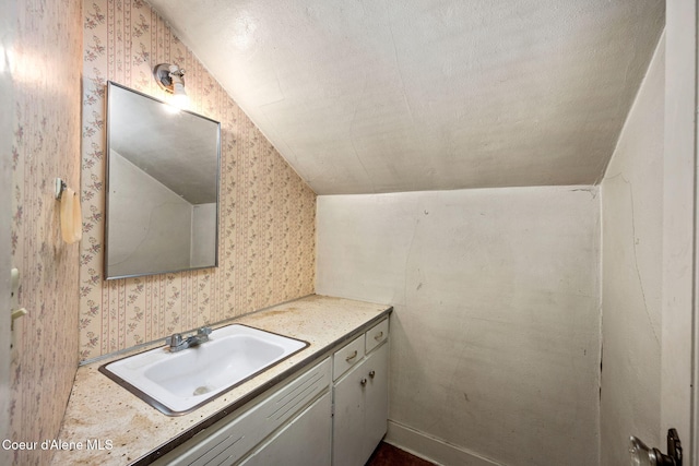 bathroom with wallpapered walls and vanity