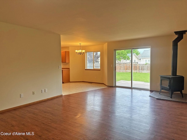 1205 Kinnikinnik Ave, Sandpoint, ID 83864 - unfurnished living room with a chandelier, light wood-style floors, and a wood stove