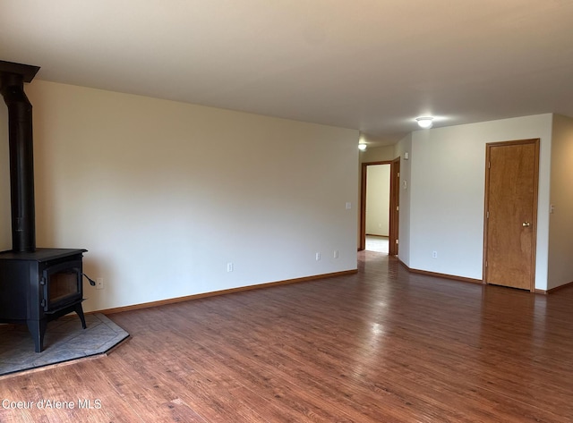 1205 Kinnikinnik Ave, Sandpoint, ID 83864 - unfurnished living room featuring wood finished floors and a wood stove