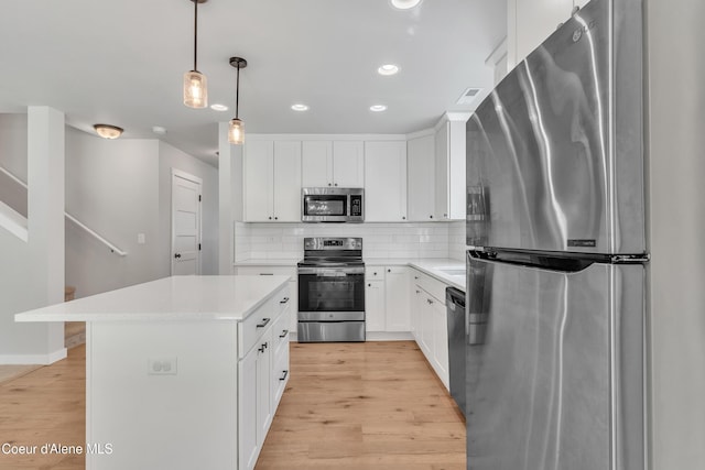 161 White Way, Priest River, ID 83856 - kitchen featuring stainless steel appliances, tasteful backsplash, light countertops, a kitchen island, and light wood finished floors