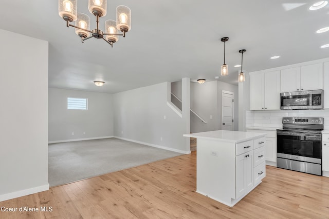 161 White Way, Priest River, ID 83856 - kitchen featuring stainless steel appliances, light wood-type flooring, baseboards, white cabinetry, and light countertops