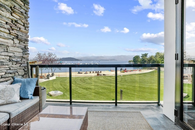 balcony featuring a water and mountain view