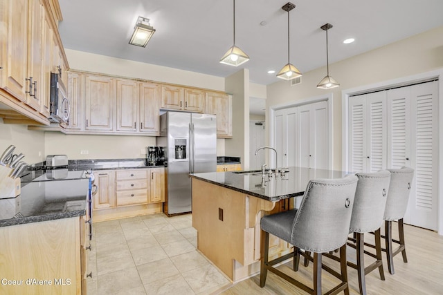 kitchen with stainless steel appliances, light brown cabinets, a sink, a kitchen breakfast bar, and recessed lighting