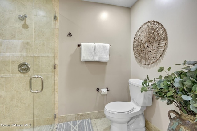 bathroom featuring a stall shower, tile patterned flooring, baseboards, and toilet