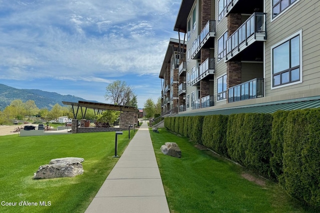 view of community with a mountain view and a lawn